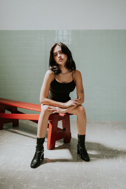 A woman sitting on a red bench in a bathroom