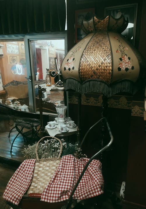 A lamp with a basket and a tablecloth on it