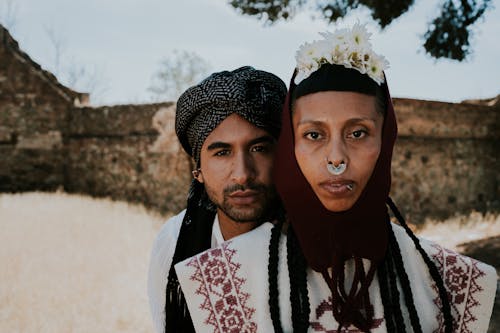 A Man and Woman Posing Outside in Traditional Clothing 