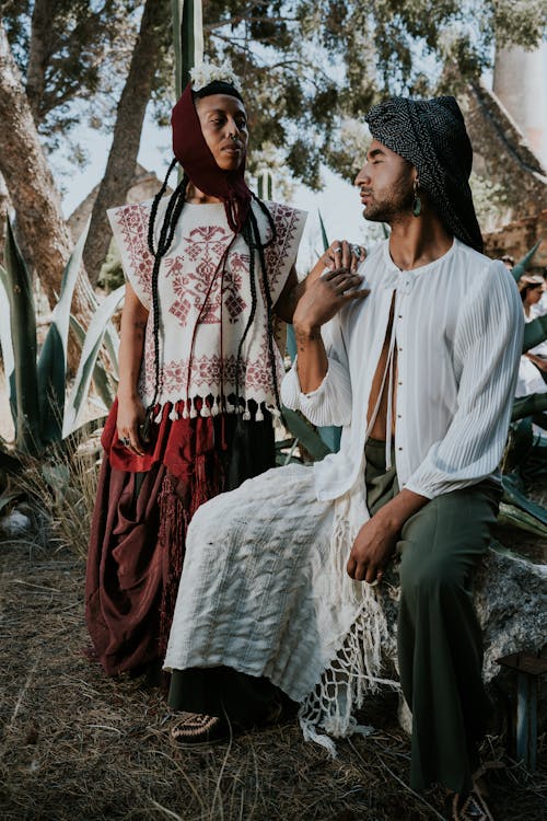 A Man and Woman Posing Outside in Traditional Clothing 