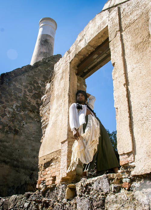 Model in Wide Olive Pants and a Loose White Shirt Posing in the Ruins