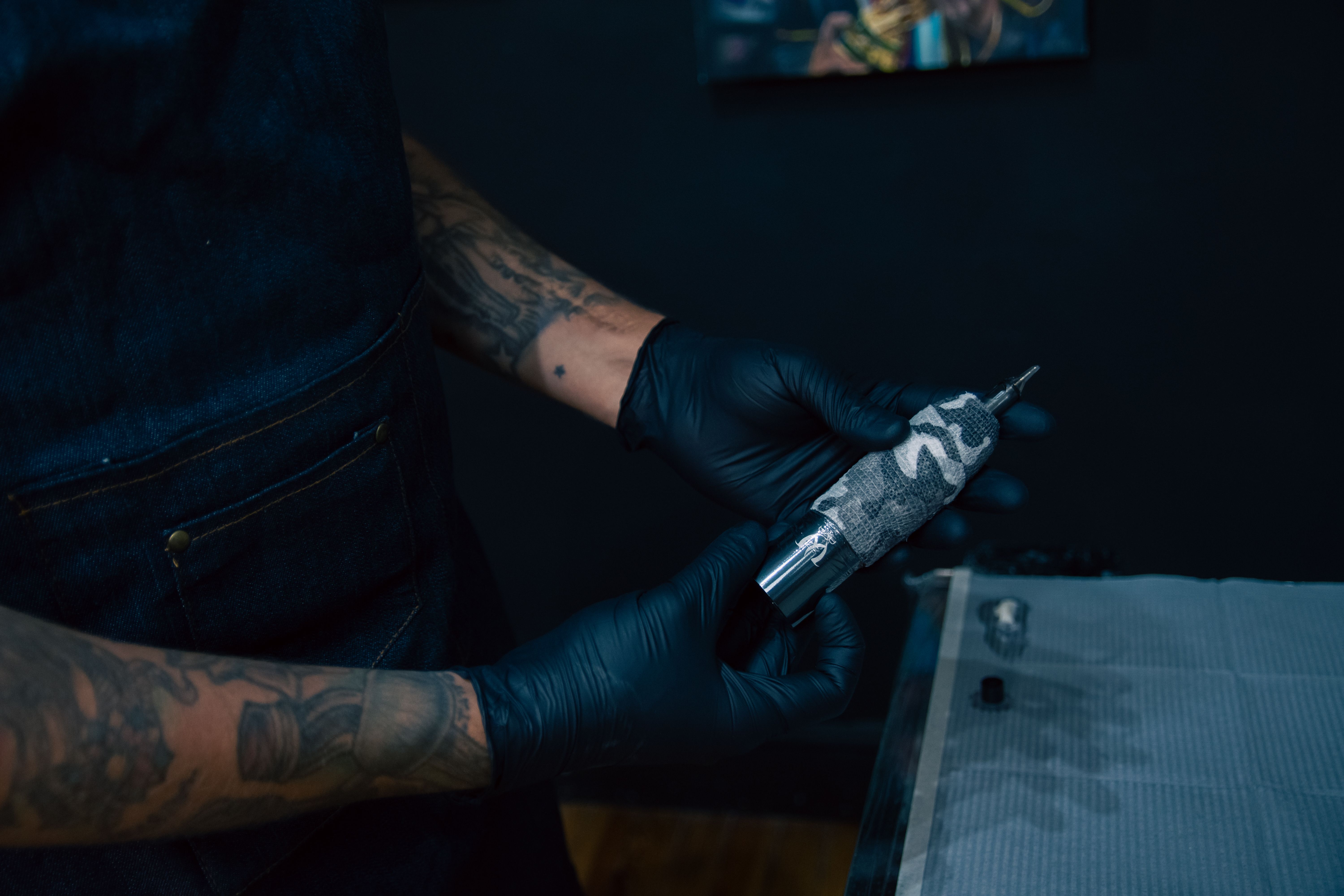 Beginner tattoo apprentice learning machine handling from a mentor