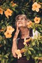 Woman Smiling Standing on Yellow Bell Flower Plant