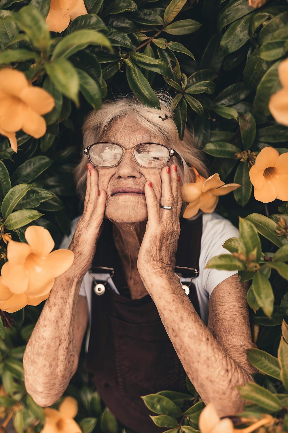 Old woman standing on yellow-petaled flower | Photo: Pexels