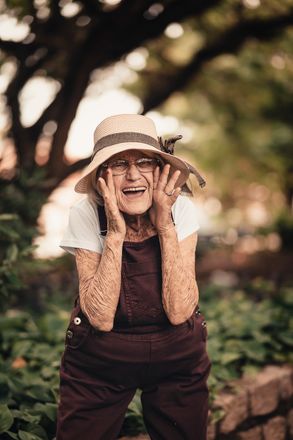 Elderly woman gently guided by a caregiver through a memory care garden