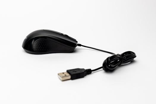 Close-up of a black wired USB computer mouse on a seamless white background, showcasing tech elegance.