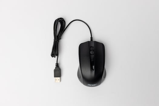 Top view of a black wired computer mouse on a clean white surface.