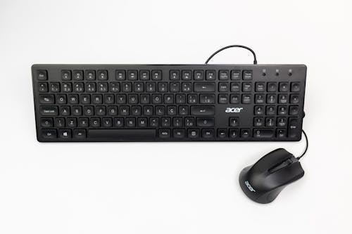 A Black Computer Keyboard and Mouse on White Background 