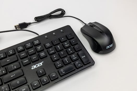 Close-up view of black wired Acer keyboard and mouse with USB connection on a white surface.