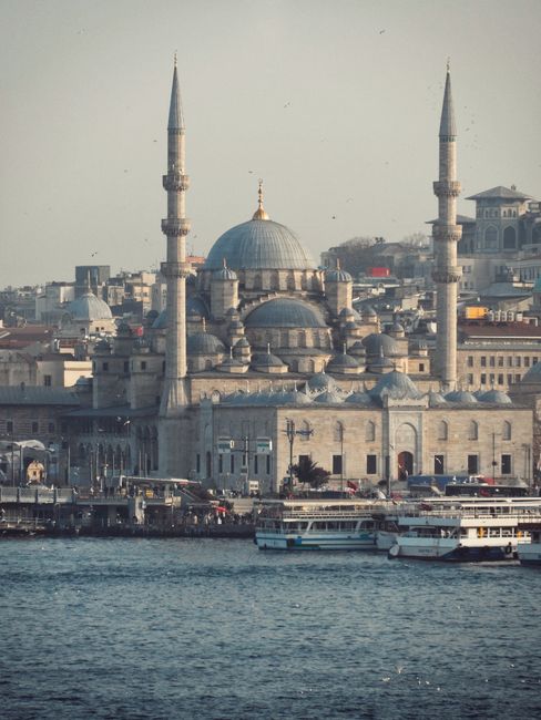 A scenic view of the New Mosque and surrounding harbor in Istanbul, Turkey.