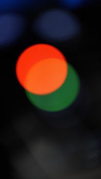 Vibrant bokeh circles in red and green create an intriguing abstract visual art piece.