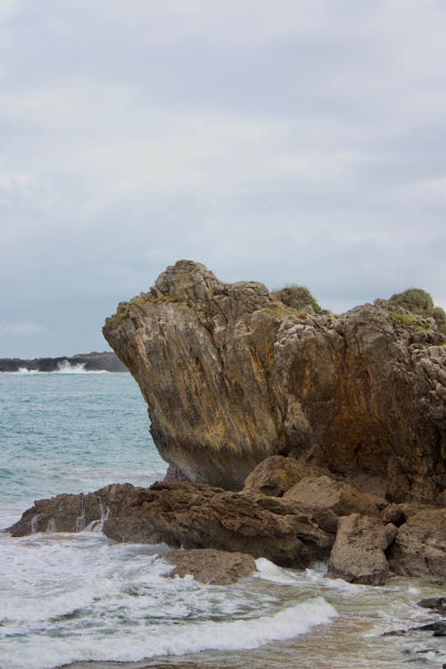 View of a Rocky Shore under a Cloudy Sky 