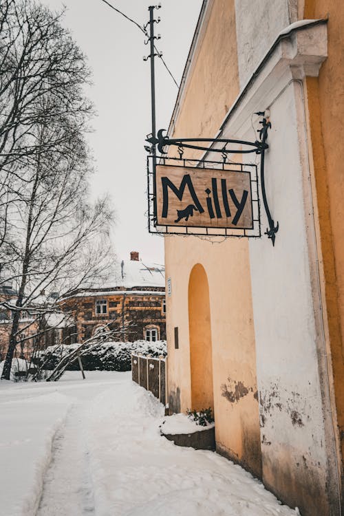 View of a Sign Hanging Outside of a Building in Winter 