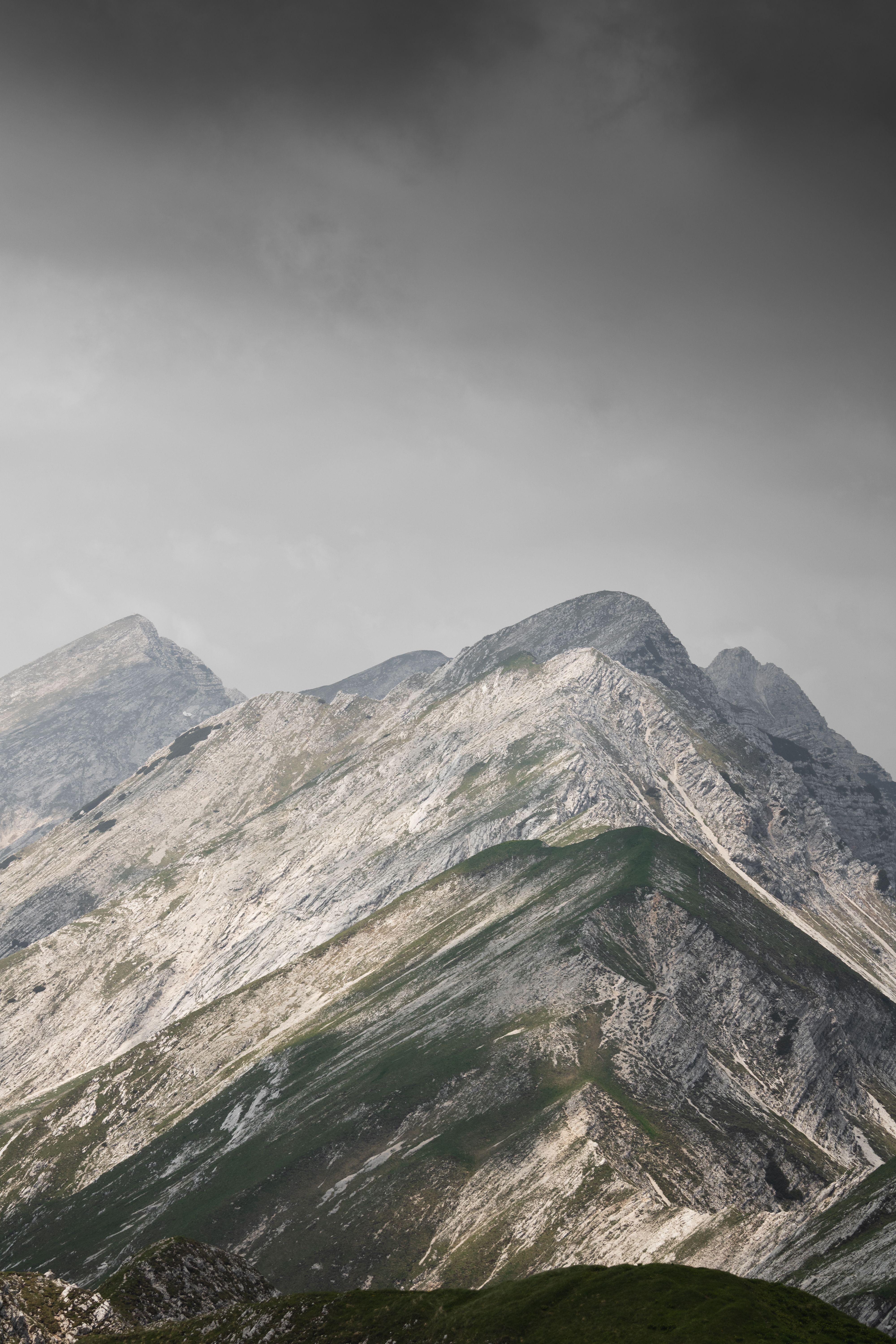 A mountain range with a cloudy sky and dark clouds · Free Stock Photo