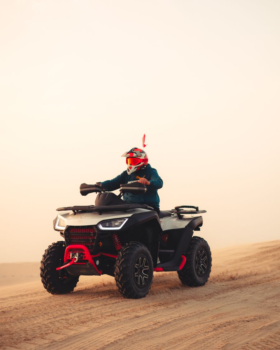 Pilote sur un quad sportif dans le désert