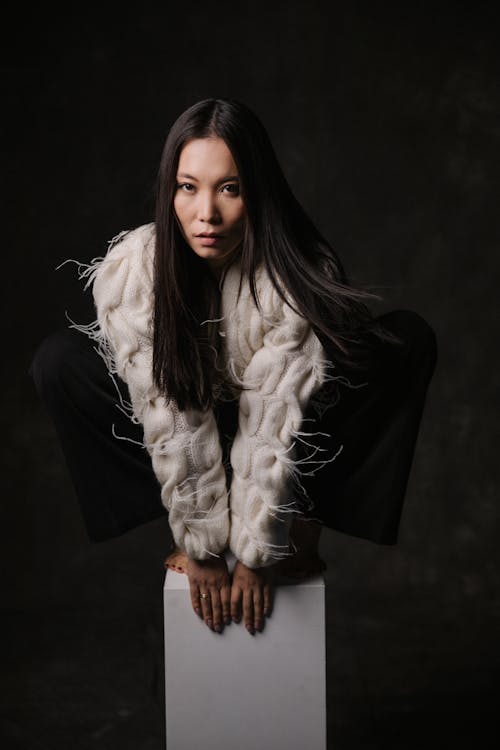 A woman in a white fur coat posing on a box