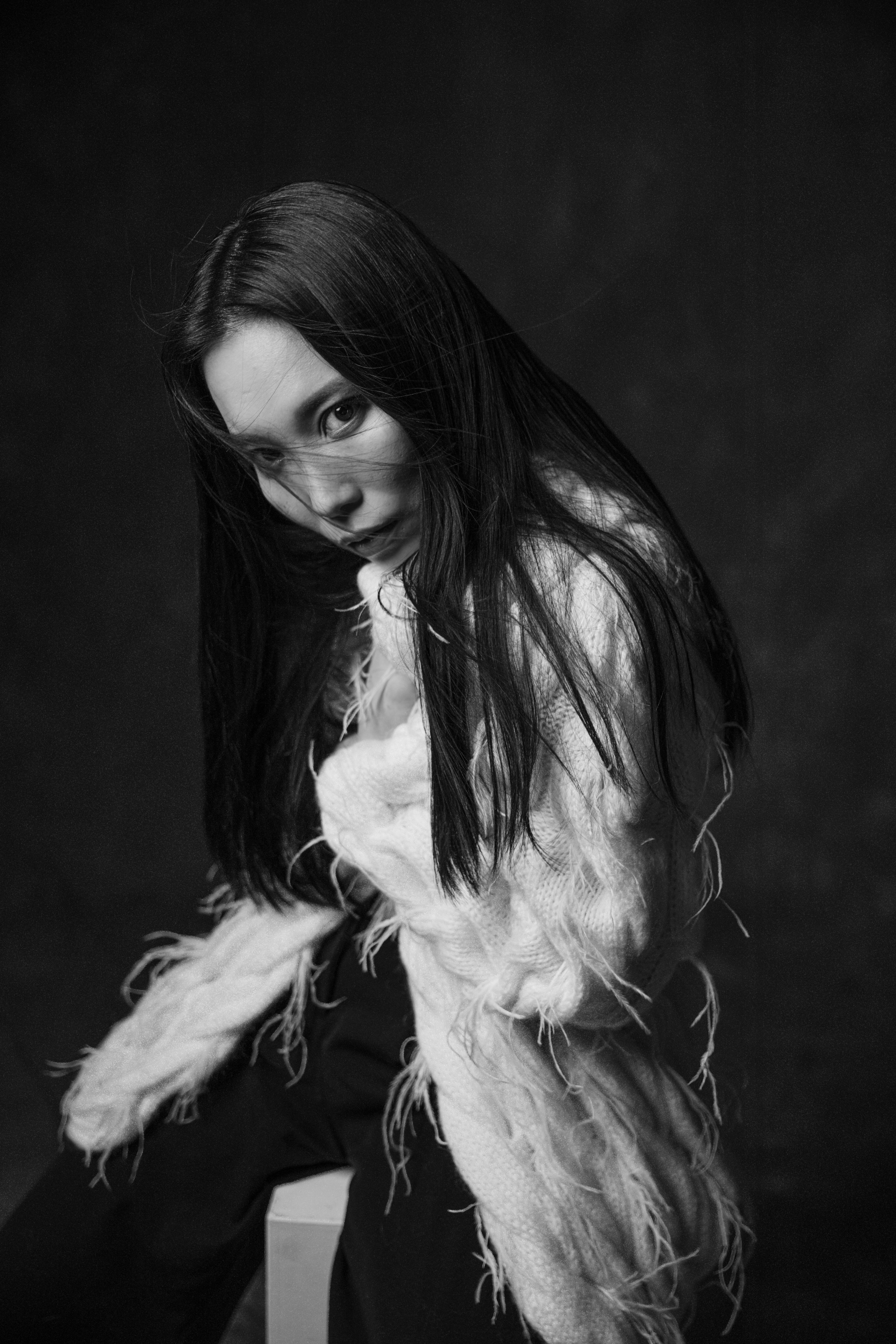 Elegant black and white portrait shot featuring a woman in a stylish outfit for a studio shoot.