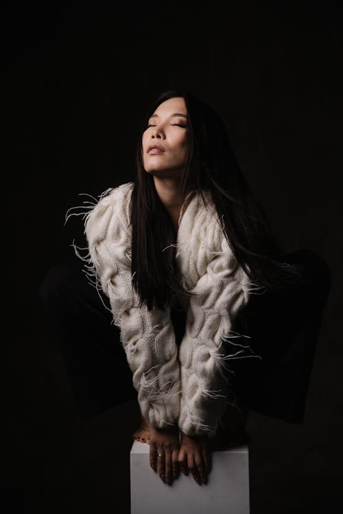 A woman in a white fur coat posing for a photo