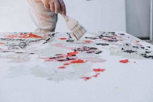 A person painting on a white table with a brush