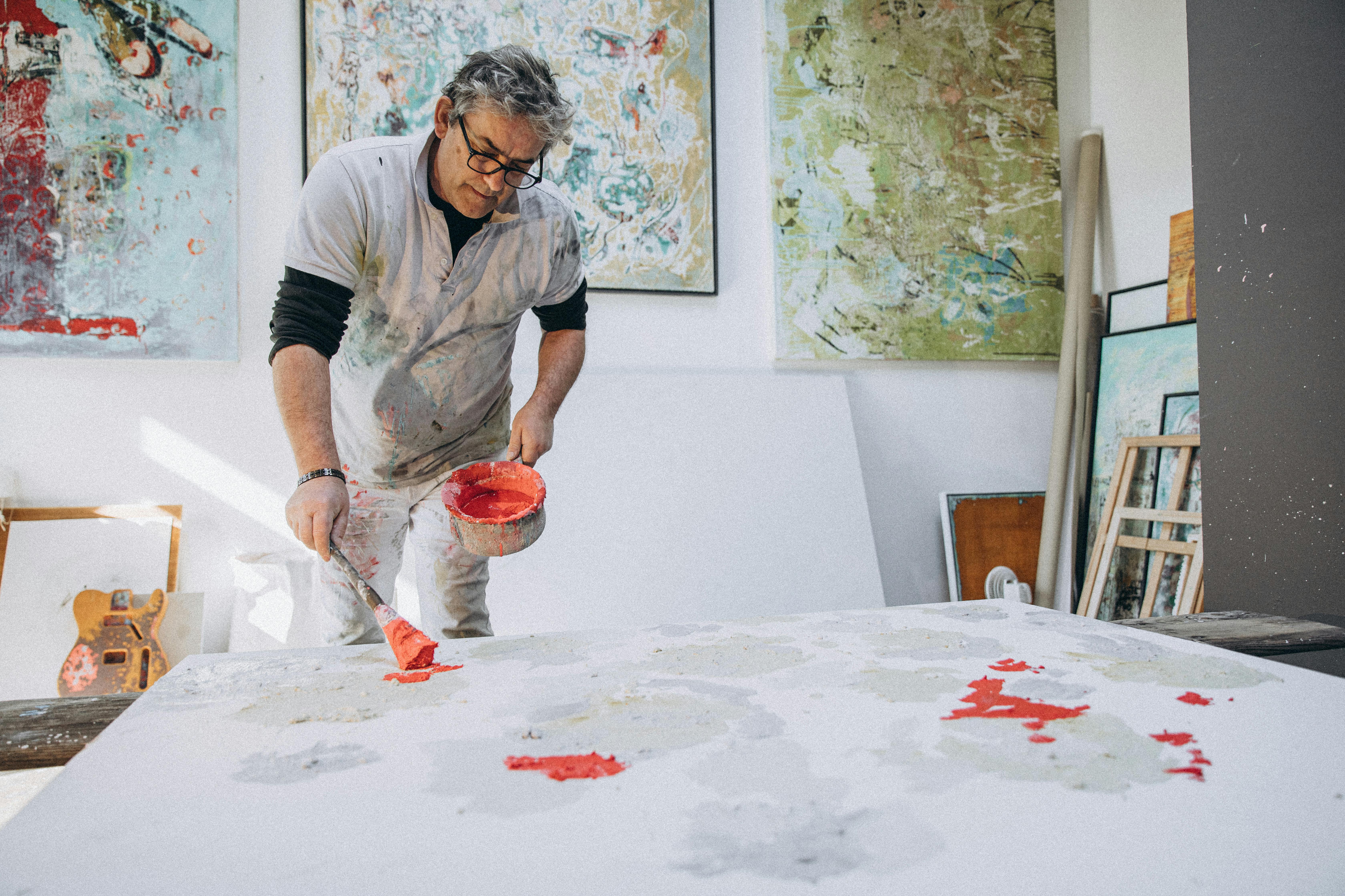 Artist with gray hair painting in a vibrant studio environment. Captivating and colorful artwork.