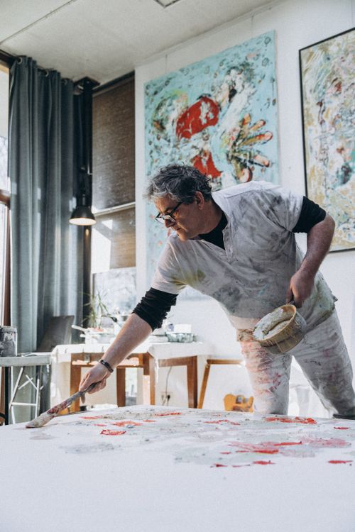 Free A male artist passionately paints in a bright and airy studio space. Stock Photo