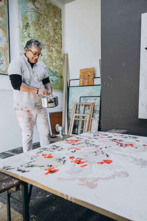 Free A smiling artist with gray hair creatively paints in a bright studio. Stock Photo