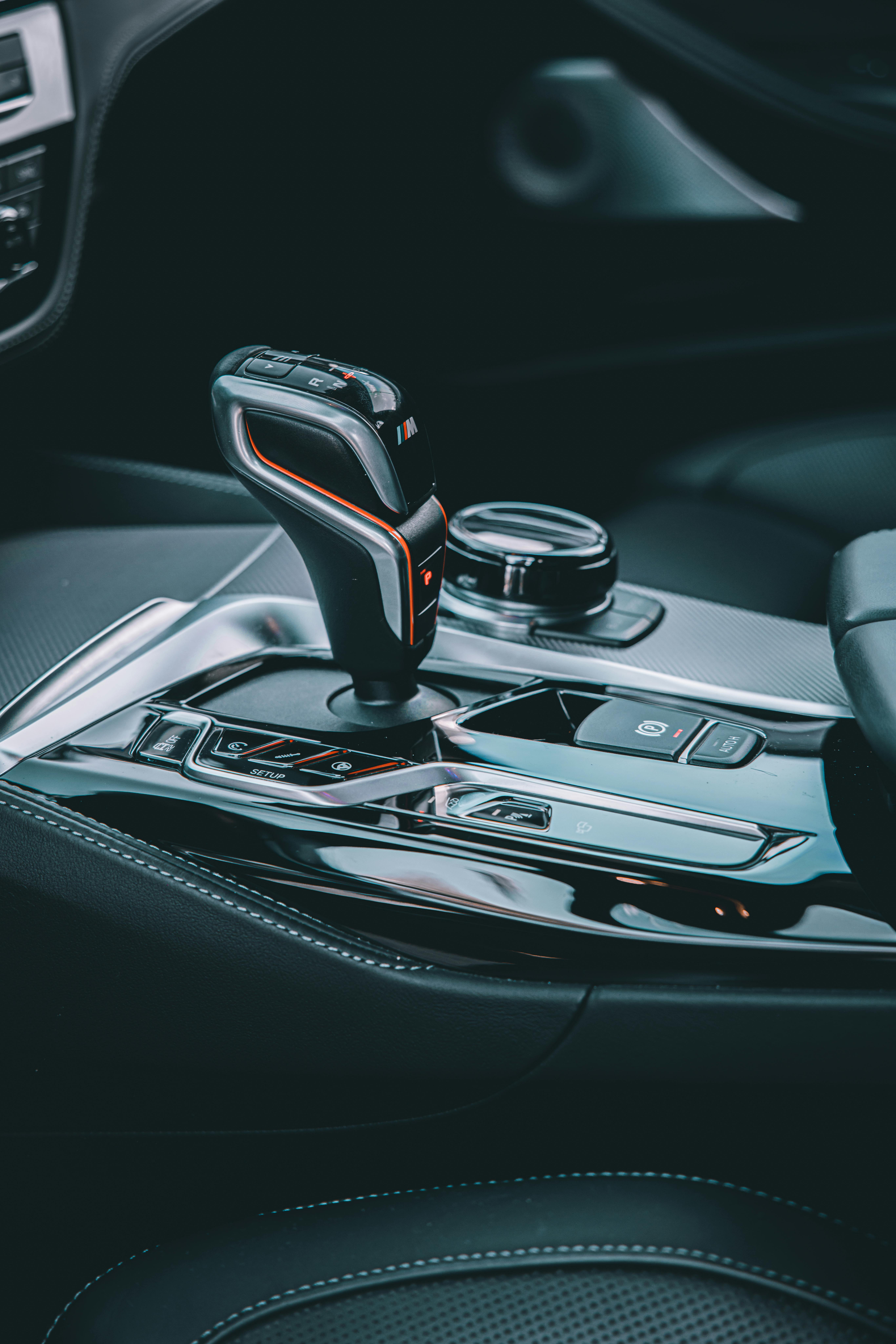 Free Close-up shot of a modern vehicle's gear stick and dashboard, highlighting sleek design. Stock Photo