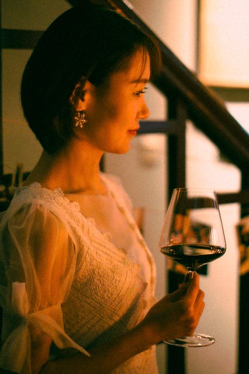 Side View of an Elegant Woman Holding a Glass of Wine 