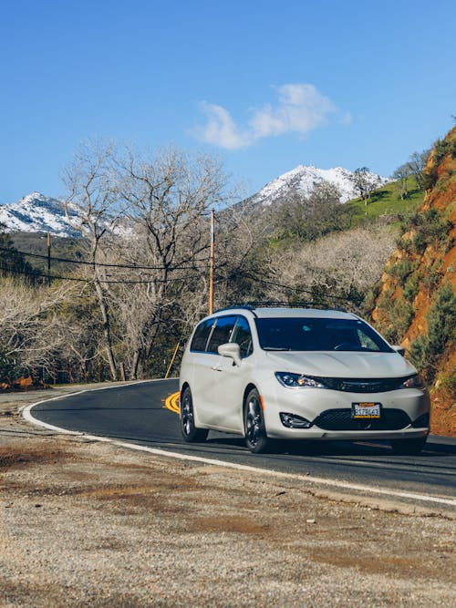 The chrysler pacifica is driving down a road