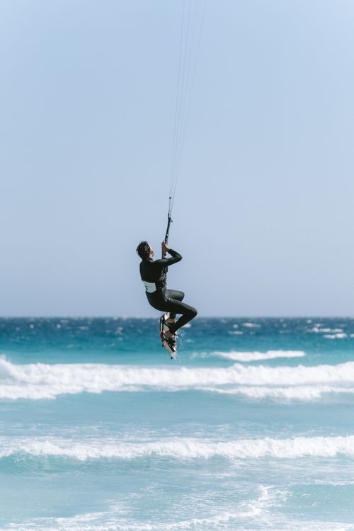Free High flying kitesurfer in midair over waves at Esperance Beach, Australia, showcasing skill and adventure. Stock Photo