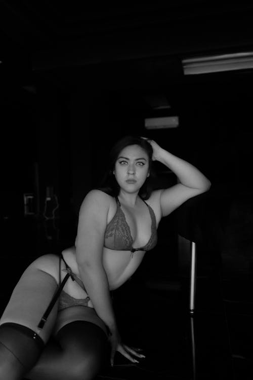 A woman in lingerie posing in a black and white photo