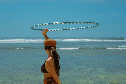 the girl playing hullahoop at a beach