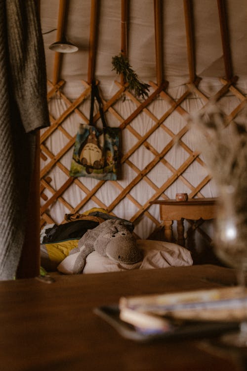 A bed inside a yurt with a book on the table