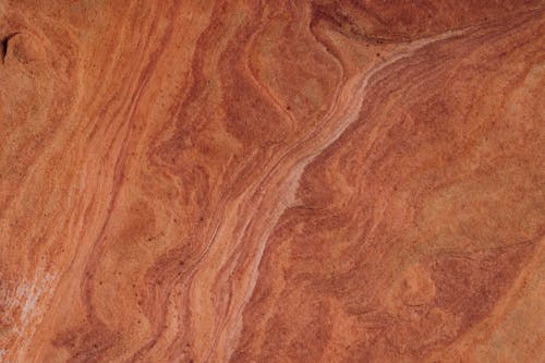 A close up of a wood surface with red and brown colors