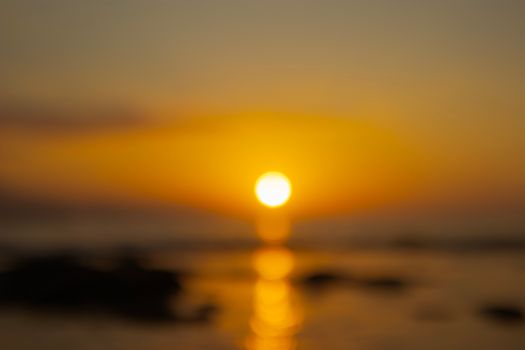 Golden sunset with a defocused view over the ocean creating a warm, calming scene.