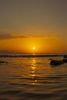 Stunning sunset view over the ocean with golden reflections on the water surface.
