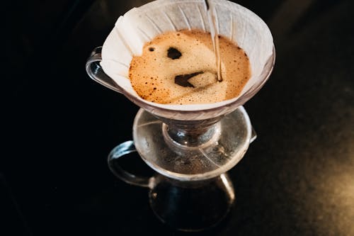 A coffee dripper pouring coffee into a cup