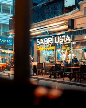 Candid view of Sabrı Usta doner shop at night with neon lights.