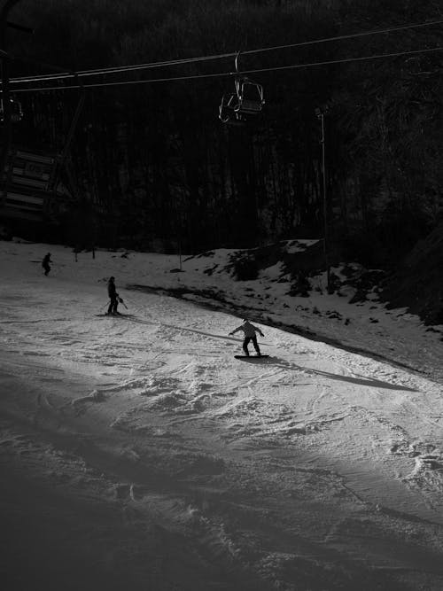 A black and white photo of people skiing
