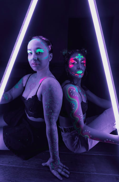 Two women with neon lights on their bodies