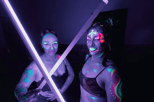 Two women with glowing lights on their arms