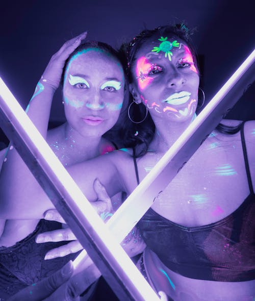 Two women with neon lights on their faces