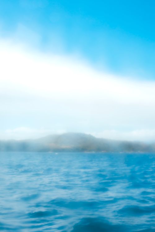 Free A peaceful ocean scene with a blurred horizon and cloudy sky, evoking tranquility. Stock Photo
