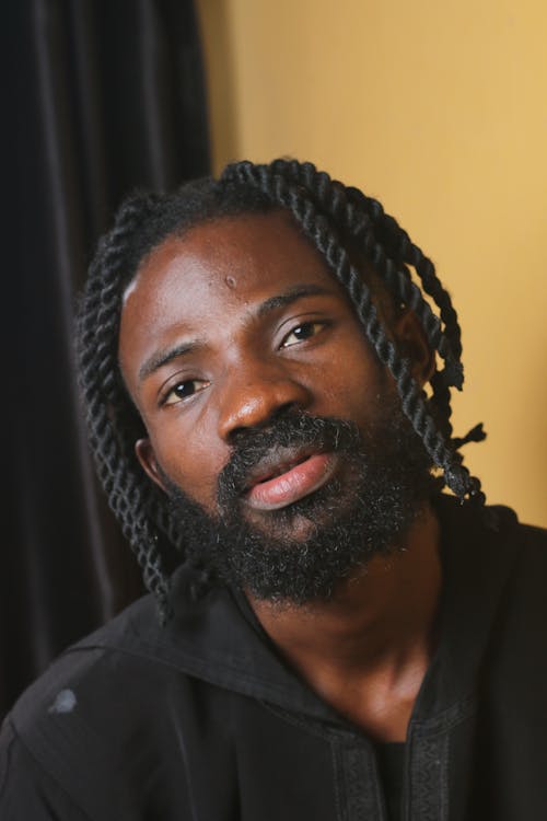 A man with dreadlocks and a black shirt