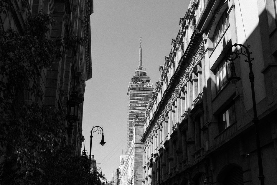 Black and white photo of Torre Latinoamericana in Mexico City's urban landscape.