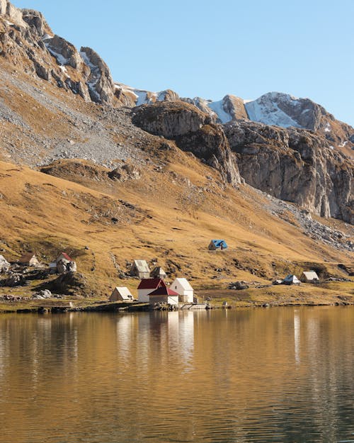 Foto d'estoc gratuïta de cases, formacions rocoses, llac