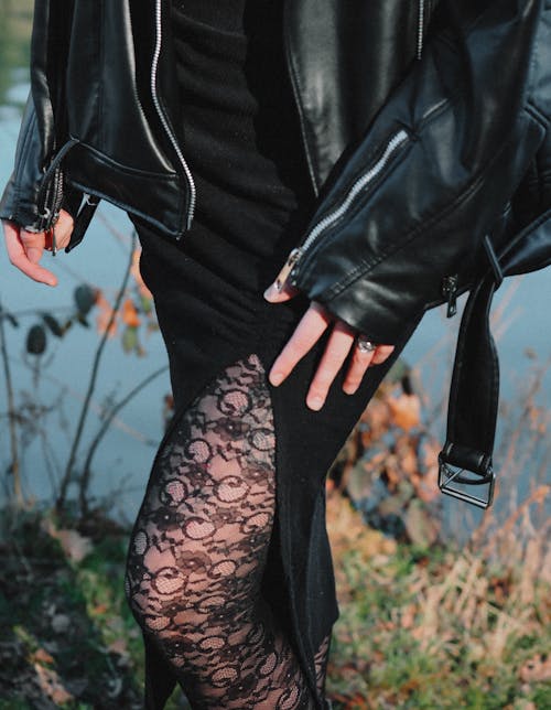 A woman in black leather jacket and lace skirt