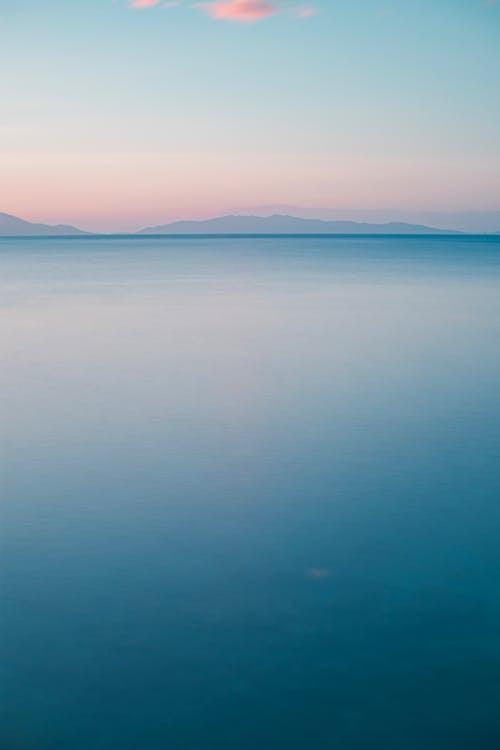 A long exposure photograph of the ocean and mountains