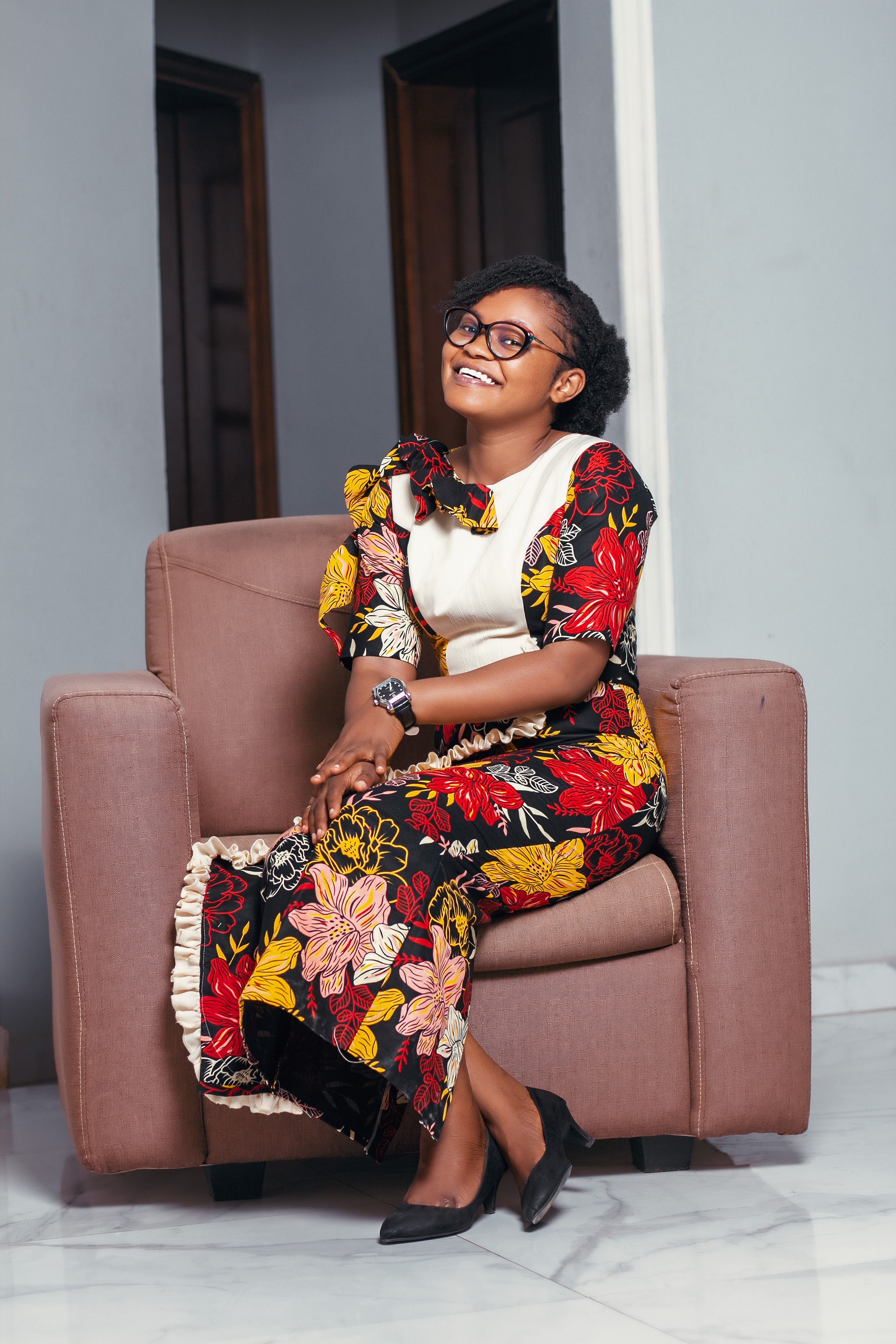 A woman in a floral dress sitting on a chair · Free Stock Photo