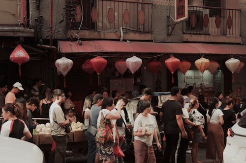 People are walking around a street with red lanterns